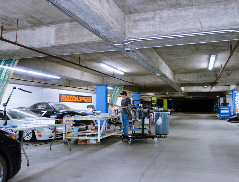 A fine hello to the basement. Those are Bonneville speed record RX-7s on the left and the nose of a 792P poking out on the right.